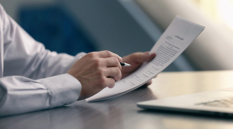 man holding paper and a pen